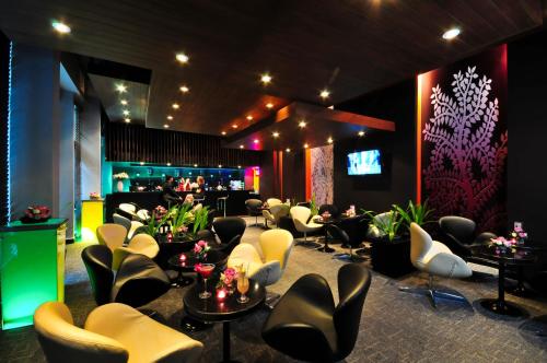 a bar with chairs and tables and a barber shop at Tara Angkor Hotel in Siem Reap