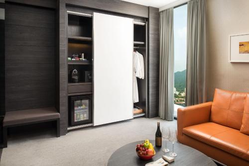 a living room with a couch and a table with a bottle of wine at G Hotel Kelawai in George Town