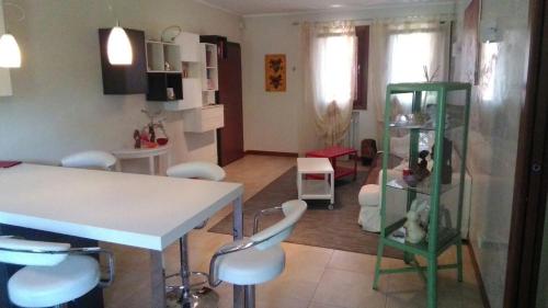 a living room with a table and some white chairs at Casa Felicité - di Francesca e Antonio in Valmareno