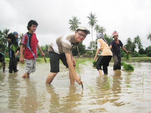 a group of people walking in the water at Homestay Zulaika Kota Aur in Kepala Batas