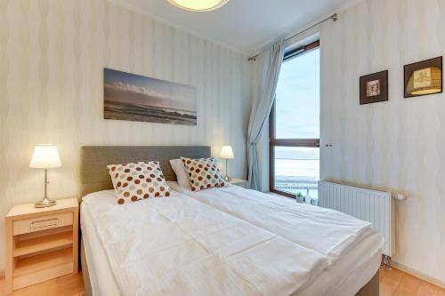 a bedroom with a white bed with a large window at The Marine Plaza - Sea Towers in Gdynia