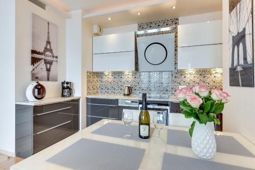 a kitchen with a table with a vase of flowers at The Marine Plaza - Sea Towers in Gdynia
