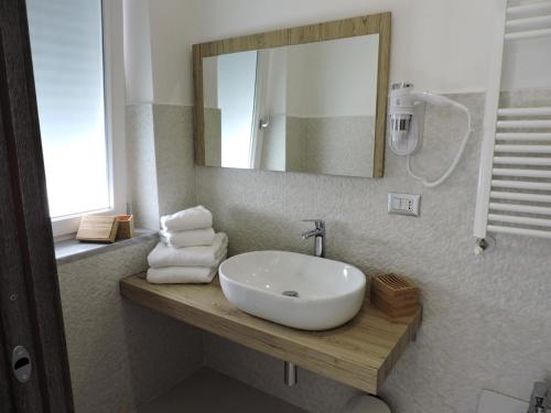 W łazience znajduje się umywalka, lustro i ręczniki. w obiekcie Cilentorooms Paestum w mieście Paestum