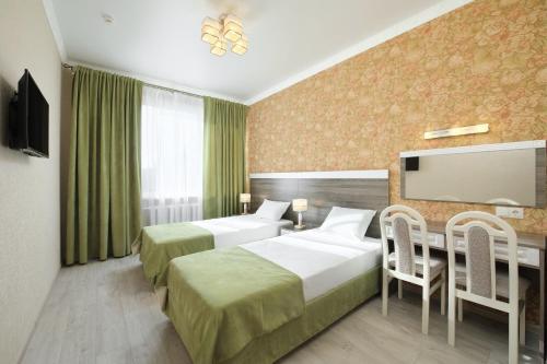 エッセントゥキにあるSanatoriy Imeni Pavlovaのベッド2台とテレビが備わるホテルルームです。