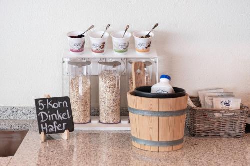 a kitchen counter with a shelf with containers of food at Mercure Chur City West in Chur