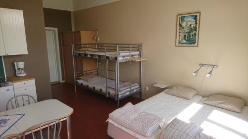 a room with two beds and a table and a kitchen at Tossene Vandrahem in Hunnebostrand