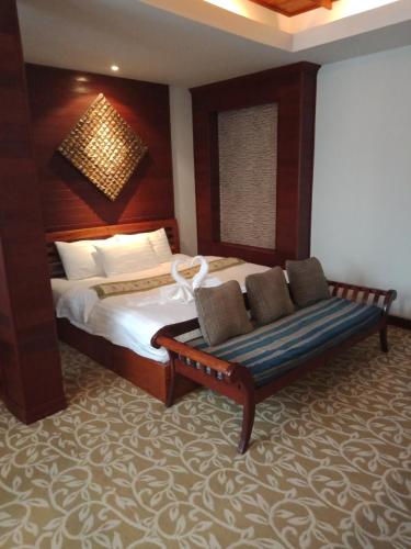 a bedroom with a bed and a couch in it at Charming Lao Hotel in Ban Chéng