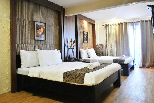 Una habitación de hotel con dos camas y una ventana. en Altamare Dive and Leisure Resort Anilao, en Mabini