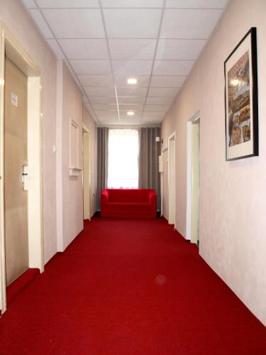 a corridor with a red couch in a hospital hallway at Pension Village in Karlovy Vary