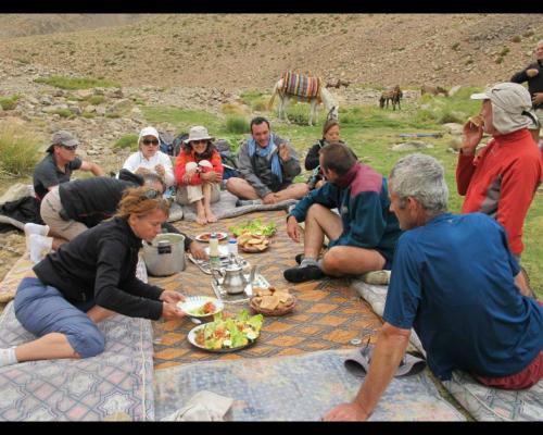 a group of people sitting around a table eating food at Gîte Atlas Mazik in Imlil