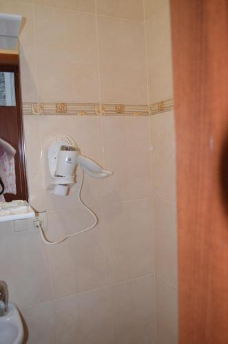 a bathroom with a hair dryer on the wall at SunLake Hotel Osokorki in Kyiv