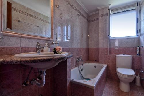 uma casa de banho com um lavatório, um WC e uma banheira em Angelica's House em Mantoúkion