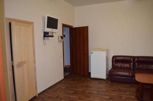 a living room with a couch and a television on the wall at SunLake Hotel Osokorki in Kyiv