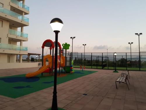 a playground with a slide and a light pole at Apartamento playa Piles in Piles