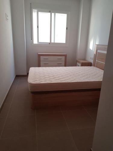 a bed in a room with a window at Apartamento playa Piles in Piles