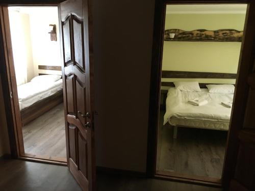 a mirror in a room with a bed and a bedroom at Cheremosh in Yablunytsya