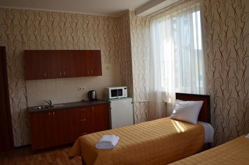a hotel room with two beds and a microwave at SunLake Hotel Osokorki in Kyiv