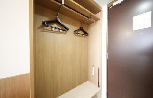 a bathroom with a shower with a wooden door at Vessel Hotel Campana Okinawa in Chatan