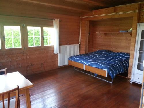 a bedroom with a bed in a wooden room at Koningsheim in Colijnsplaat