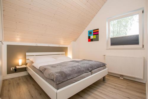 ein Schlafzimmer mit einem großen Bett und einem Fenster in der Unterkunft Ferienhaus Hafenkante mit Sky in Nordhorn