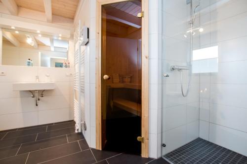 ein Bad mit einer Dusche und einem Waschbecken in der Unterkunft Ferienhaus Hafenkante mit Sky in Nordhorn