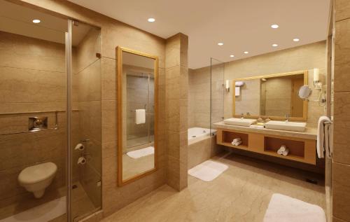 uma casa de banho com um WC, um lavatório e um chuveiro em Lemon Tree Hotel, Gachibowli, Hyderabad em Hyderabad