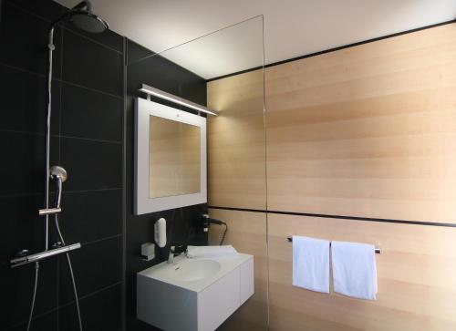 a bathroom with a white sink and a mirror at MN Hotel by WMM Hotels in Mindelheim