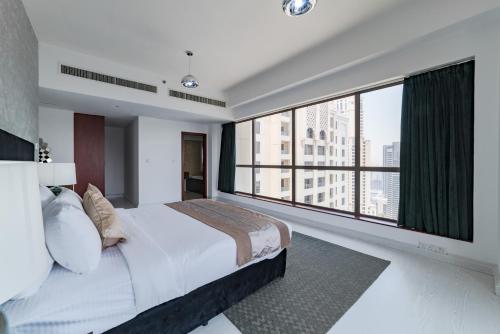 sypialnia z dużym łóżkiem i dużym oknem w obiekcie Icon Casa Living - Rimal 6-JBR Marina view w Dubaju