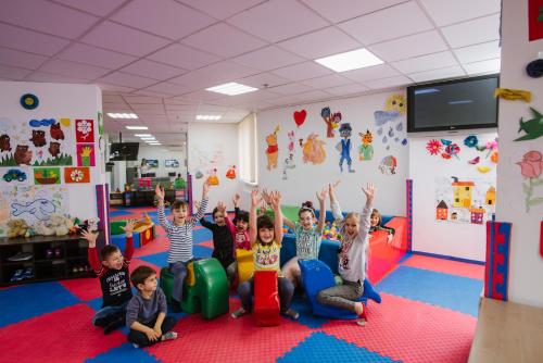 a group of children sitting in a room with their hands in the air at Lisova Pisnia Resort Hotel in Truskavets