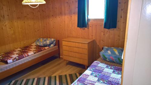 a small room with two beds and a window at Skogheim Two-Bedroom Cottage in Birkeland