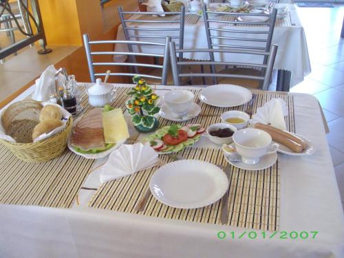 a table with white plates and food on it at Malinka in Rewal