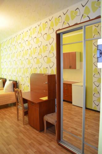 a living room with a desk and a bedroom at SunLake Hotel Osokorki in Kyiv