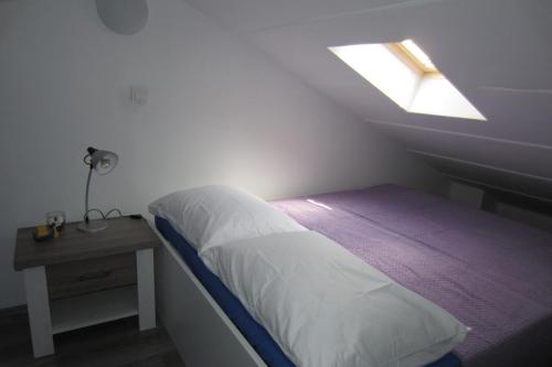 a small bedroom with a bed and a window at Apartman Valinor in Miholašćica