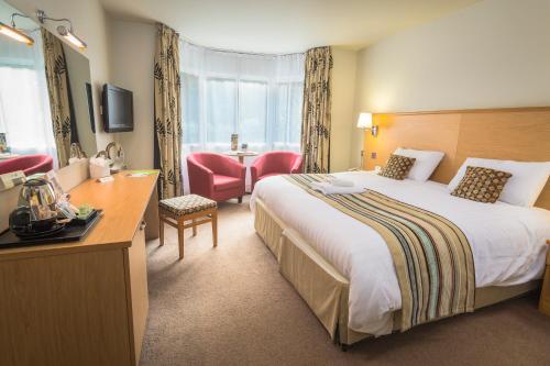 a hotel room with a large bed and a desk at Best Western The Dartmouth Hotel, Golf & Spa in Dartmouth