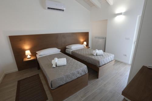 2 Betten in einem Zimmer mit zwei Lampen in der Unterkunft Casa San Valentino in Bussolengo