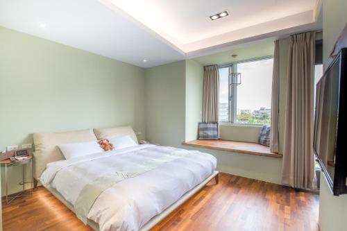 a bedroom with a large bed and a large window at WMS Villa in Dongshan