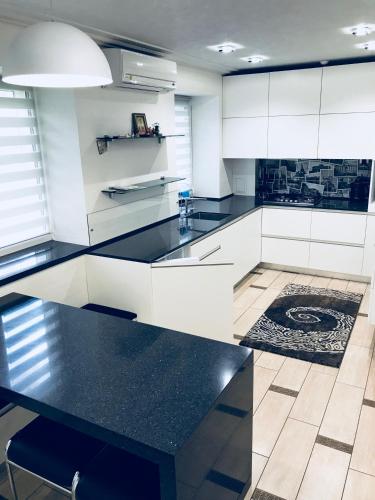 a kitchen with white cabinets and a black counter top at Apartment at Kvitka Polonyny in Solochin