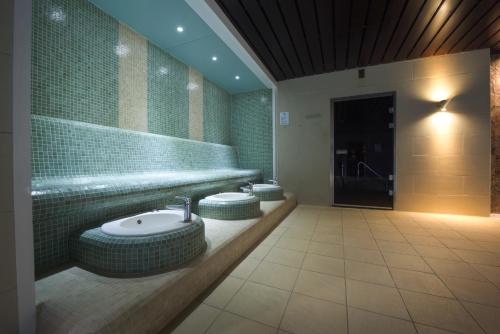 a bathroom with a sink and two stools at Bicester Hotel, Golf & Spa in Bicester