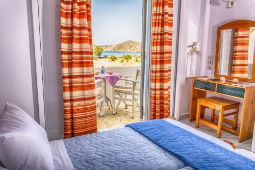 a bedroom with a bed and a view of the ocean at Hotel Helena in Ios Chora