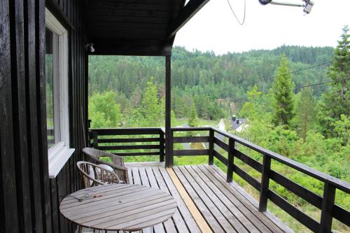 eine Veranda mit einer Bank und einem Tisch auf dem Balkon in der Unterkunft Bergheim Two-Bedroom Cottage in Birkeland