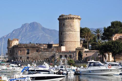 a group of boats in a harbor with a castle at Casa Michela, sea-view apartments in Trabia