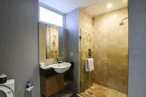 a bathroom with a sink and a shower at The Malibu Suites Balikpapan by Sissae Living in Balikpapan