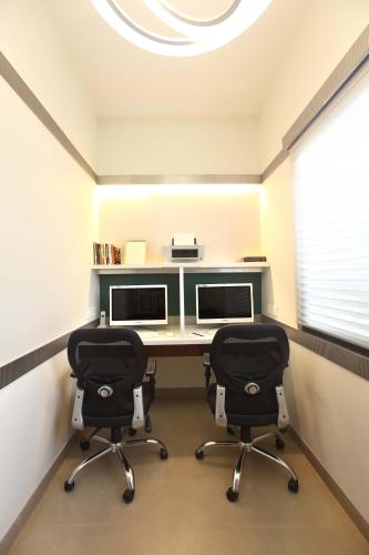 an office with two desks and two chairs at Mirage Hotel, Mumbai International Airport in Mumbai