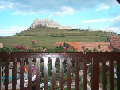 a balcony with a view of a castle on a hill at A+S Penzion Podzamok in Spišské Podhradie