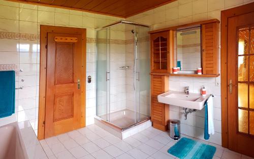 ein Bad mit einer Dusche und einem Waschbecken in der Unterkunft Bungalow & Apartments "Am Deber" Velden - Augsdorf in Velden am Wörthersee