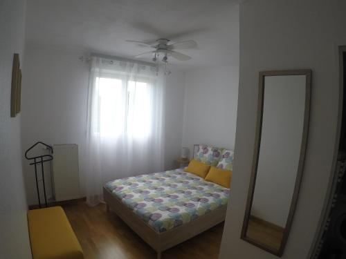 1 dormitorio con cama, espejo y ventana en Renoir Appartement, en Cagnes-sur-Mer