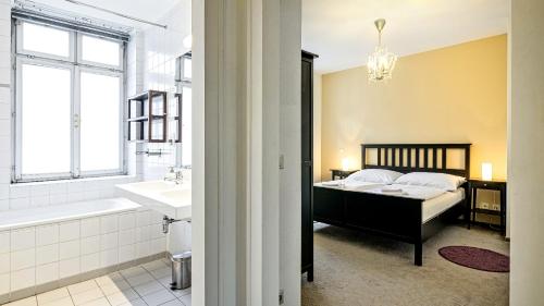 a bathroom with a bed and a tub and a sink at Penzion Dvořákova in Brno