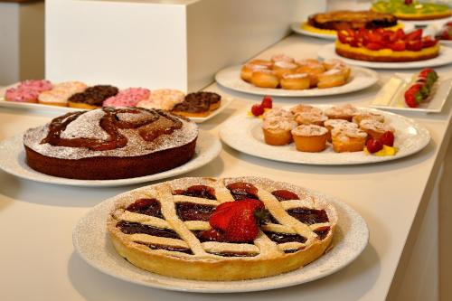 a table topped with plates of cakes and pastries at Hotel Concord - Nel cuore di Riccione in Riccione
