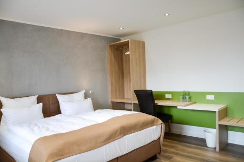 1 dormitorio con 1 cama grande, escritorio y en Hotel-Restaurant Kölbl, en Enkenbach-Alsenborn