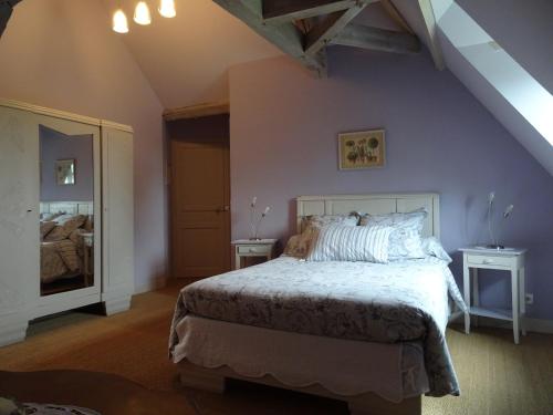 a bedroom with a large bed and a blue wall at Le Clos des ifs in Thiétreville